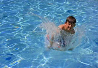 Boy splashing in pool